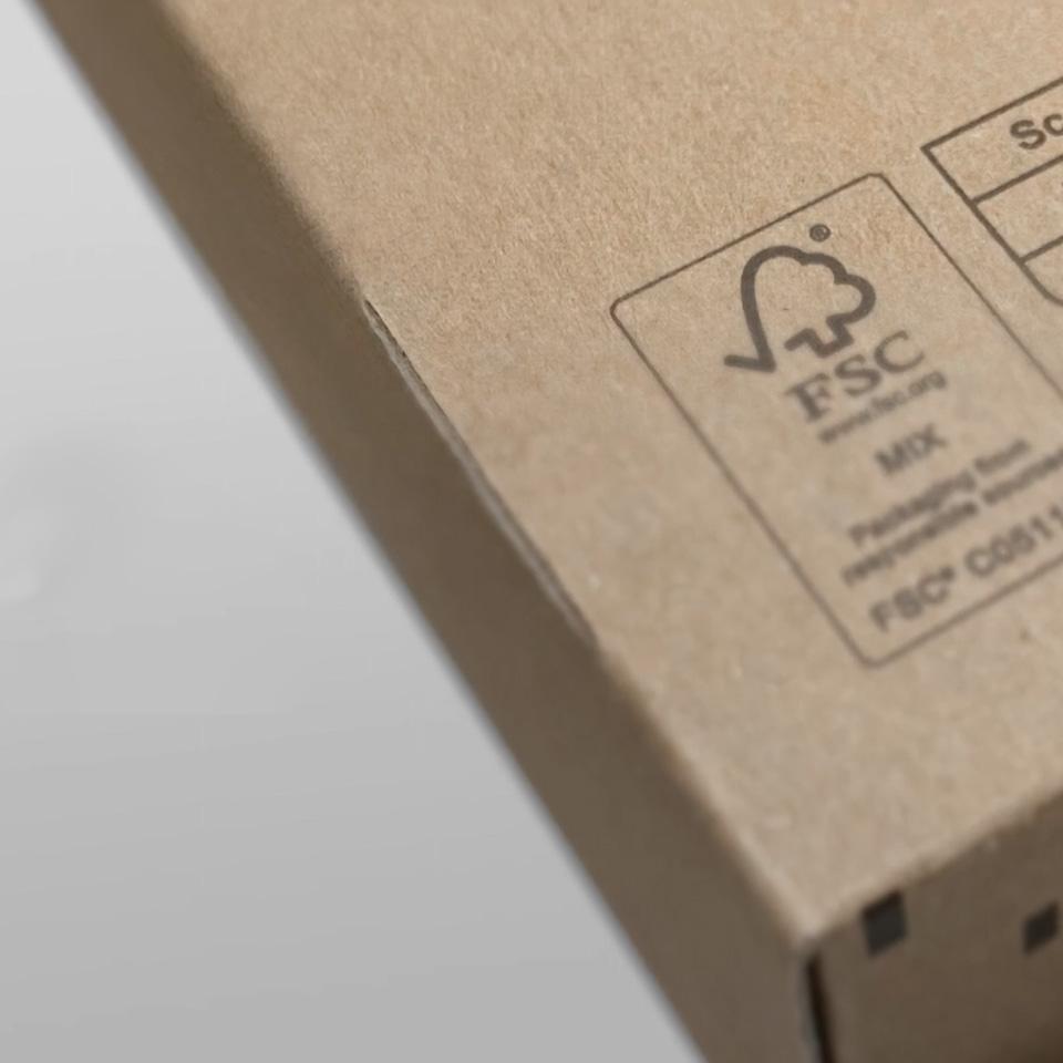 Primo piano di una scatola di cartone con il simbolo della carta mista certificata FSC stampato sulla superficie.